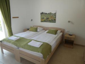 a bedroom with two beds and a painting on the wall at Villa More in Pučišća