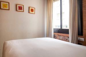 a bedroom with a white bed and a window at Bcn-rentals apartments in the Old town in Barcelona