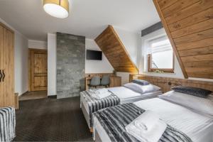een hotelkamer met twee bedden en een trap bij Janosówka in Czarna Góra