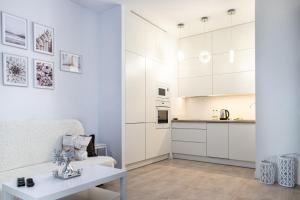 a living room with white cabinets and a table at Wola Glamour Apartment in Warsaw