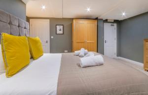 um quarto grande com uma cama grande e almofadas amarelas em Gillygate Boutique Apartment- Stunning City Centre 1 Bedroom Apartment em York