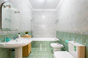a bathroom with a sink and a toilet and a tub at Villa Cañete in Benamocarra +23 photos