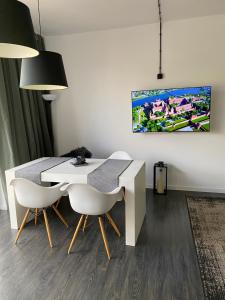 a dining room with a white table and chairs at Apartament Kościuszki in Malbork