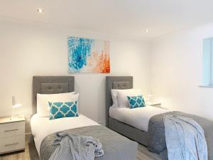 a bedroom with two beds and a painting on the wall at 2 Bedroom Holiday Home near Bolton, Appleby-in-Westmorland in Kirkby Thore