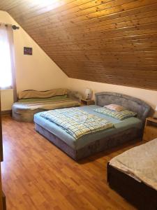 a bedroom with two beds and a wooden ceiling at Edit Vendégház Balatonszentgyörgy in Balatonszentgyörgy