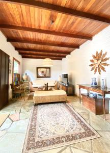 a large living room with a bed and a table at Pouse no Jardim in Pirenópolis