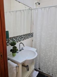 y baño blanco con lavabo y ducha. en LAUQUEN II en Trenque Lauquen