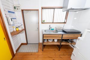 eine kleine Küche mit einer Spüle und einer Theke in der Unterkunft Pine Tree in Kamakura