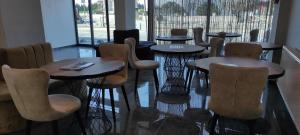 a row of tables and chairs in a restaurant at Acar Airport Hotel Plus in Arnavutköy