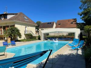 a swimming pool with chairs at L'Annexe- guest house avec piscine studio avec coin chambre in Rosny-sur-Seine