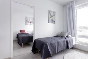 a bedroom with two beds and a mirror at Apartment, SleepWell, Nuutti in Turku