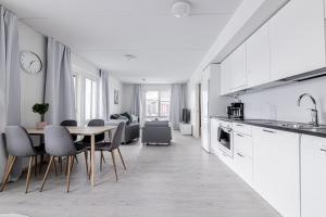Apartment, SleepWell, Nuutti في توركو: مطبخ وغرفة طعام مع طاولة وكراسي