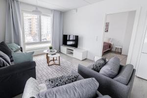 a living room with two couches and a tv at Apartment, SleepWell, Nuutti in Turku