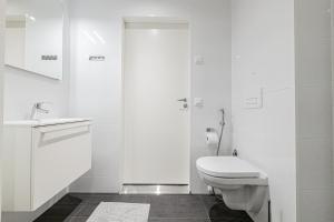Baño blanco con aseo y lavamanos en Apartment, SleepWell, Nuutti en Turku