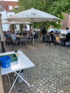 una mesa con sombrilla y personas sentadas en mesas en Lippborger-Hof, en Lippetal