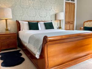 a bedroom with a wooden bed and two lamps at The Broomsquire in Aldermaston