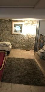 a room with a stone wall and a rug at Le Paradis in Theux