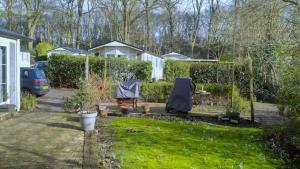 a yard with a fence and some plants at Boshuisje- Chez Michel in Wageningen