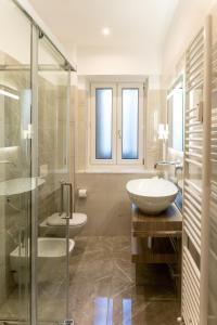 a bathroom with a sink and a glass shower at Hotel Victoria in Cuneo