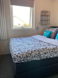 Ένα ή περισσότερα κρεβάτια σε δωμάτιο στο BelleMare Bungalow Lauwersmeer mit überdachte Veranda und eingezäuntem Garten
