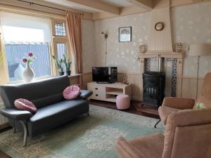 a living room with a couch and a fire place at Vakantiehuis Doelestee in Balk