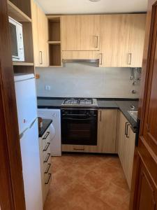 Una cocina con estufa y refrigerador blanco. en ALTURA T1, en Altura