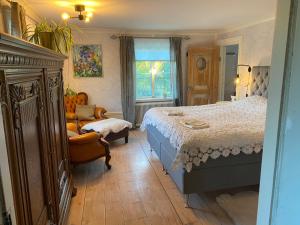 a bedroom with a bed and a couch and a chair at Amiralsgården Verstorp in Karlskrona