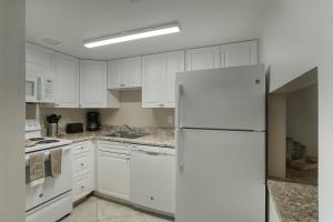 La cuisine est équipée de placards blancs et d'un réfrigérateur blanc. dans l'établissement 206 Fully Furnished 1BR Suite-Prime Location, à Scottsdale