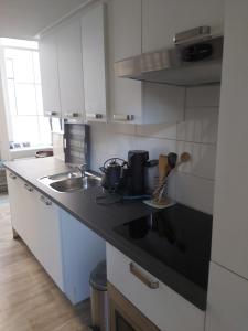 a kitchen with white cabinets and a black counter top at Stadslogement 8 in Zwolle