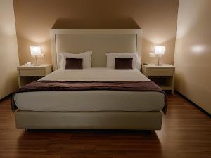 a bedroom with a large bed with two night stands at Hotel Monte Lírio in Espinho