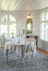 a dining room with a table and chairs and a mirror at Amiralsgården Verstorp in Karlskrona