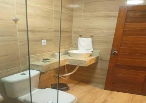 La salle de bains est pourvue d'un lavabo et de toilettes. dans l'établissement Pousada Nobre, à São Miguel do Gostoso