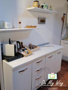 um balcão de cozinha branco com comodidades para preparar café em La Casetta em Stresa
