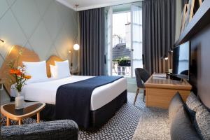 a hotel room with a bed and a tv at Millésime Hôtel in Paris