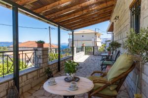 patio con mesa y sillas en el balcón en Konstas Stone Island House in Meganisi en Meganisi