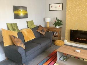 uma sala de estar com um sofá e uma TV em Whitegate 1st floor Apartment em Llandudno