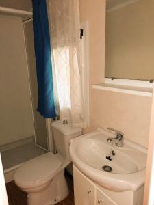 Łazienka z białą toaletą i umywalką w obiekcie Tobacco Road camping Sirolo w mieście Sirolo