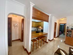 cocina con paredes blancas y armarios de madera en Casa Inma. Espacio y confort en Arrecife, en Arrecife
