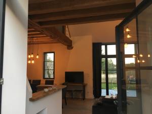 a living room with a couch and a television at Les gîtes du Val de Chambord in Huisseau-sur-Cosson