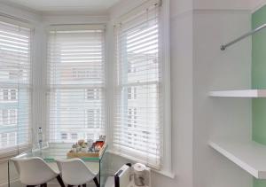 a dining room with a glass table and white windows at Hotel Nineteen in Brighton & Hove