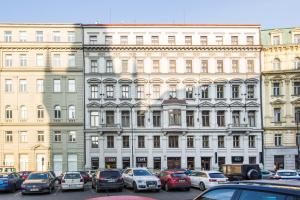 a large building with cars parked in a parking lot at The Grand Royal 3BDR Heart of Old Town in Prague