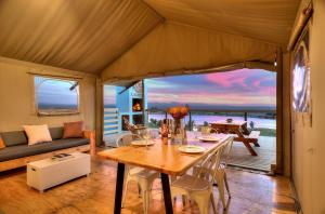 - une salle à manger avec une table et une vue sur l'océan dans l'établissement AfriCamps at Stanford Hills, à Stanford