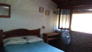 Habitación pequeña con cama y ventana en El Caserio Casas de Campo en Villa Cura Brochero