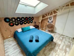 Un dormitorio con una cama azul con discos en la pared en Superbe LOFT centre-ville - Sauna - parking privé -Clim- 1 à 10personnes en Brive-la-Gaillarde
