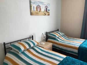 duas camas uma ao lado da outra em um quarto em Whitegate 1st floor Apartment em Llandudno