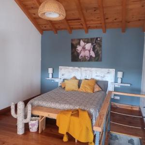 Casa Ada في تيخيدا: غرفة نوم بسرير مع مخدات صفراء