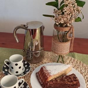 een tafel met een stuk taart en een vaas met bloemen bij Casa Ada in Tejeda