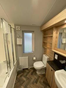 a bathroom with a toilet and a sink at Beryl Lodge with Hot Tub in York +9 photos
