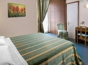 una camera d'albergo con letto e sedia di Hotel Acerboli a Rimini
