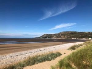 a view of a beach with a hill in the background at Whitegate in Llandudno